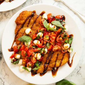 overhead shot of crispy caprese chicken on small white plate