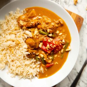 overhead shot of satay chicken in large white bowl with long grain rice
